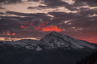 Dramatic Snow-Capped Mountain Peak Under Fiery Sunset Clouds