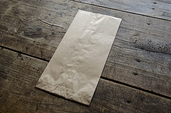 Blank Brown Paper Bag On Rustic Weathered Wooden Table Surface