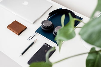 Minimalist workspace with laptop, headphones, and plant