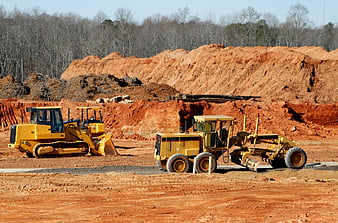 Yellow Bulldozer and Motor Grader on Red Dirt Construction Site