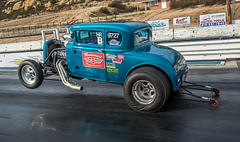 Vintage Blue Dragster Performing Wheelie on Racetrack