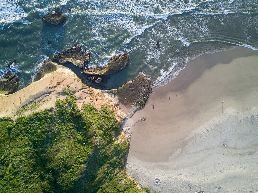 Aerial View of Rocky Coastline and Sandy Beach