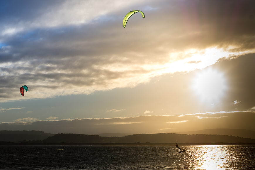 Kitesurfers Gliding on Lake at Golden Sunset