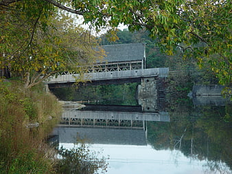 Rustic Covered Bridge Over Calm River in Autumn