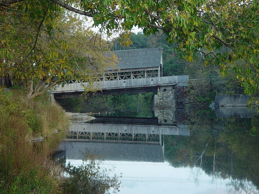 Rustic Covered Bridge Over Calm River in Autumn