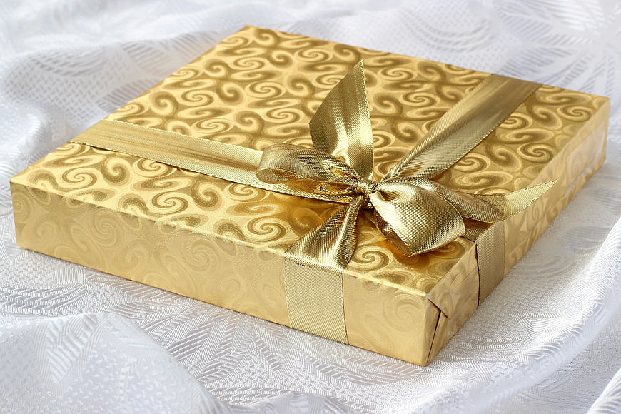 Luxurious Gold Gift Box with Ribbon on White Fabric