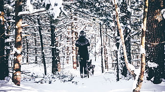 Woman Walking Dog in Snowy Winter Forest