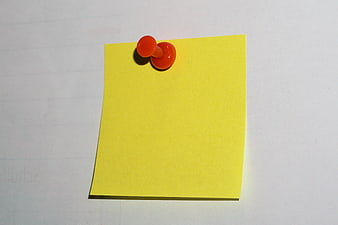 Yellow sticky note with orange push pin on white background