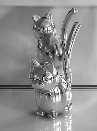 Monochrome mirrored cat figurines with reflections