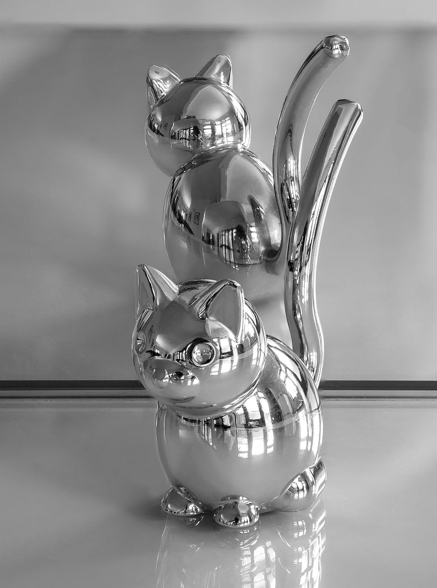 Monochrome mirrored cat figurines with reflections