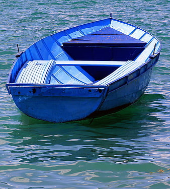 Blue wooden boat floating on calm green water
