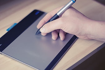 Hand Using Stylus Pen on Digital Drawing Tablet