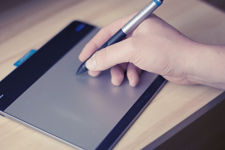 Hand Using Stylus Pen on Digital Drawing Tablet