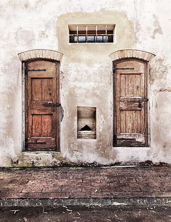 Weathered rustic wooden doors on old textured wall