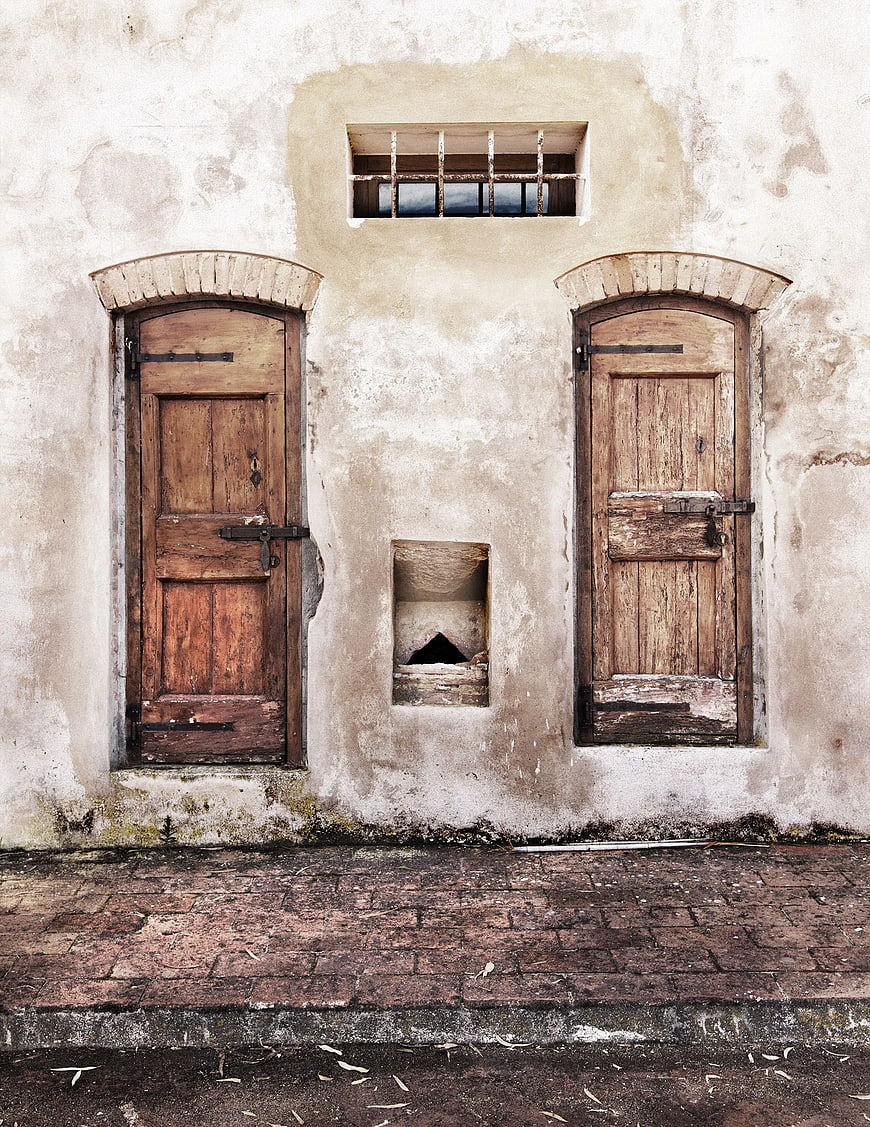 Weathered rustic wooden doors on old textured wall