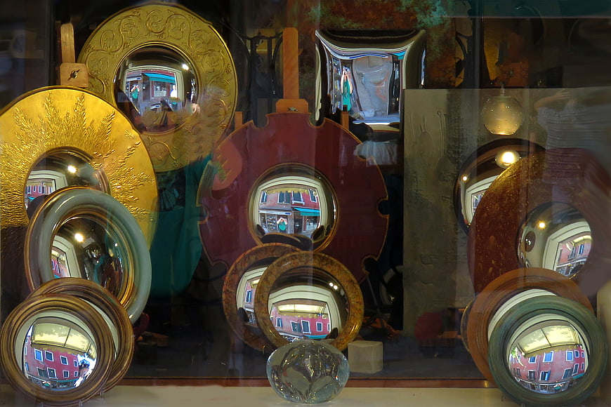 Vintage mirrors in shop window with street reflections
