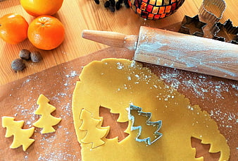 Christmas cookie dough with tree cutters and oranges