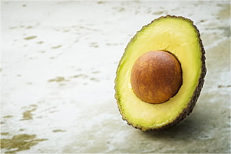 Fresh Halved Avocado with Pit on Textured Background