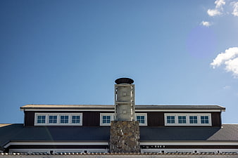 Modern House Exterior with Stone Chimney and Blue Sky