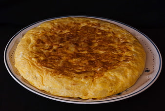 Spanish Tortilla de Patatas on White Ceramic Plate with Black Background