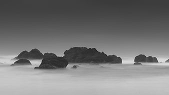 Black and white long exposure misty ocean rocks landscape