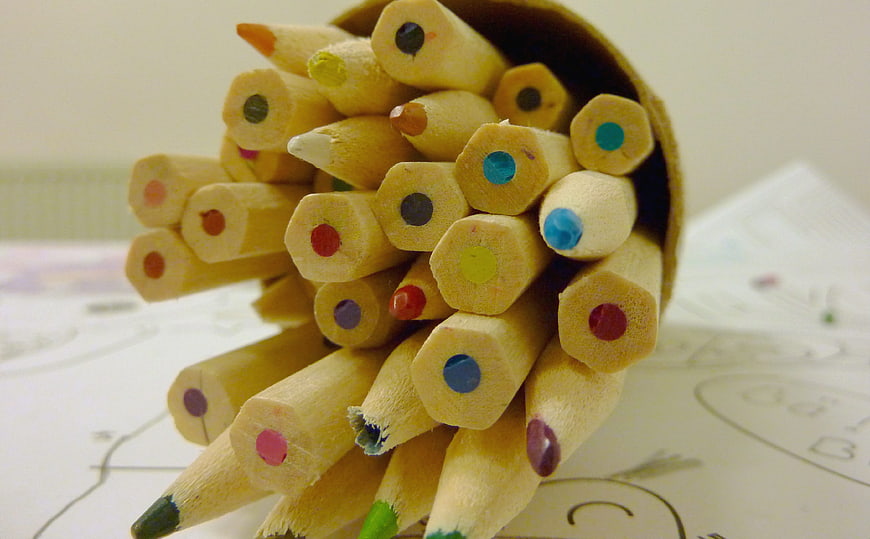 Close-up of colorful wooden pencils spilling from a cup