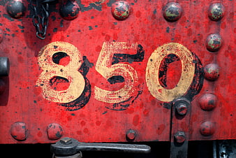 Vintage red metal plate with number 850 and rivets