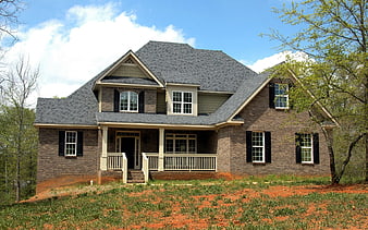 Two-story brick house with front porch and black shutters