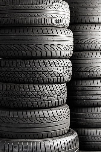 Stack of black car tires with detailed tread patterns