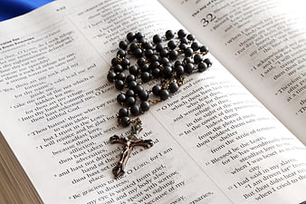 Black Rosary Beads on Open Bible Pages