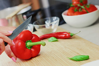 Woman Slicing Red Bell Pepper on Wooden Cutting Board