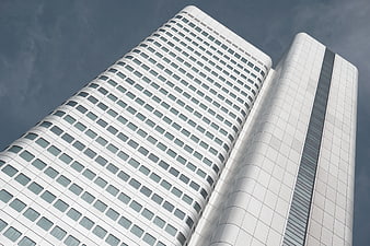 Low angle view of modern white skyscrapers against blue sky