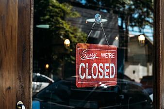 Vintage Red Closed Sign Hanging on Glass Door