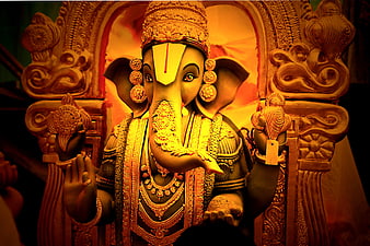 Ornate Ganesha Statue Illuminated By Warm Golden Temple Light