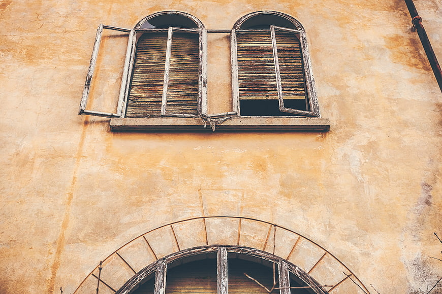 Vintage Arched Windows on Textured Yellow Stucco Wall