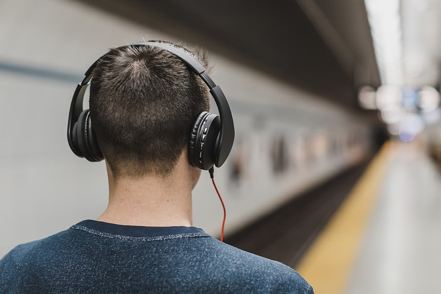 Man with Headphones on Train Platform