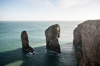 Dramatic coastal rock formations rising from turquoise ocean waters