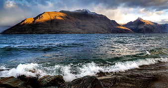 Dramatic Mountain Landscape with Golden Sunlight on Lake