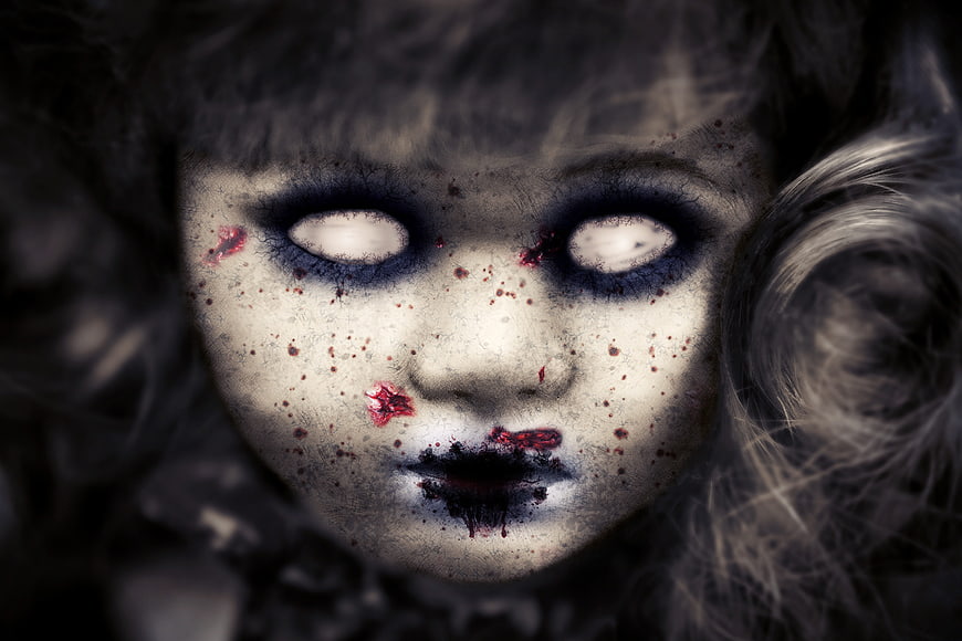 Close-up of creepy zombie doll face with blood splatters