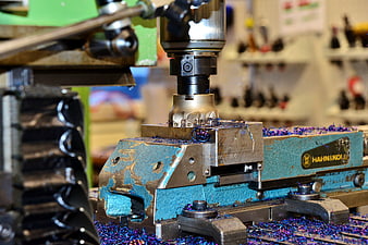 Close-up of CNC milling machine cutting metal with blue shavings
