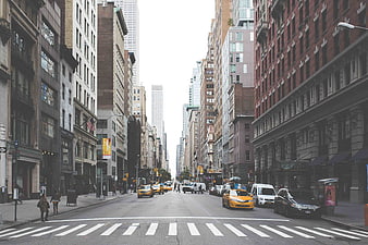 Wide City Street with Yellow Taxis and Tall Buildings