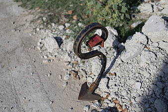 Rusty vintage plow cultivator on rocky ground