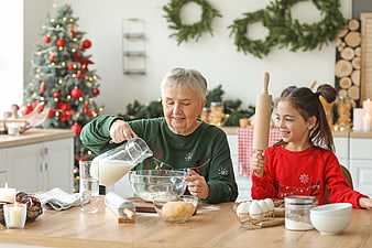 Grandmother and granddaughter baking cookies together in a festive kitchen