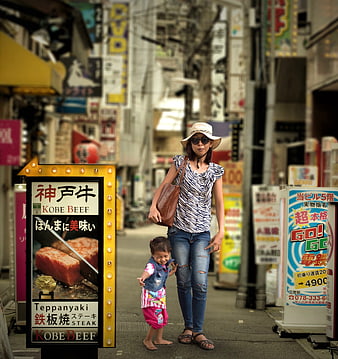 Mother and toddler walking on busy Japanese street