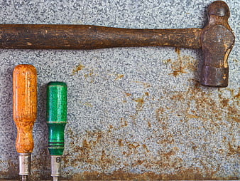 Vintage Hammer and Screwdrivers on Rusty Metal Background