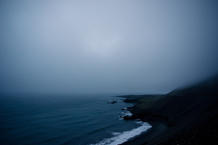 Misty dark blue ocean coastline with crashing waves