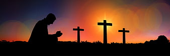 Silhouette of Man Praying Before Three Crosses at Sunset