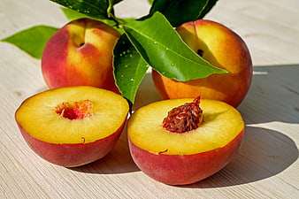 Fresh Ripe Peaches with Leaves on Wooden Table