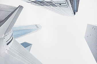 Low angle view of modern skyscrapers against white sky