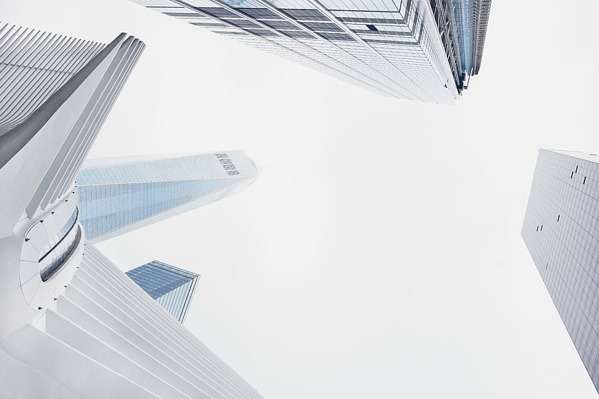Low angle view of modern skyscrapers against white sky